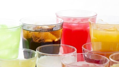 Bunte Getränke in Gläsern mit Eiswürfeln stehen nebeneinander auf einem hellen Hintergrund, ideal zum Kühlen ohne Verwässern.