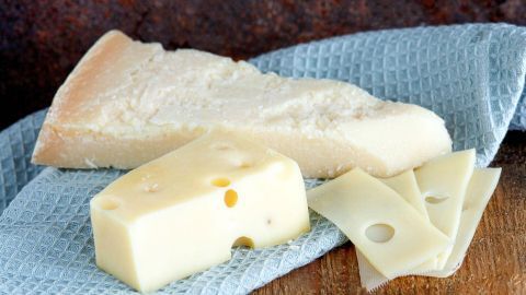 Parmesan und Emmentaler liegen auf einem blauen Küchentuch, bereit zum Überbacken oder für weitere Zubereitungen.