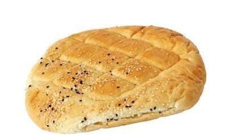 Fladenbrot liegt auf einem weißen Hintergrund; es ist mit Sesam und Schwarzkümmel bestreut.