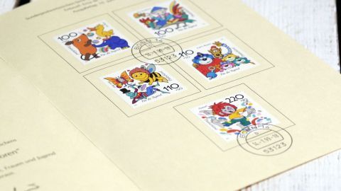 Fünf bunte Briefmarken zeigen tierische Motive und sind auf einer beige Karte angeordnet mit Poststempel.