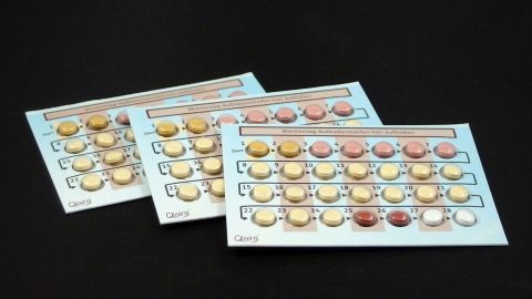 Drei Blisterpackungen der Anti-Baby-Pille liegen auf einem schwarzen Hintergrund, bereit zur Verwendung.