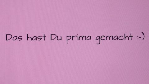 Ein positiver Text auf pinkem Hintergrund lobt: „Das hast Du prima gemacht :)". Fördert abendliches bewusstes Loben.