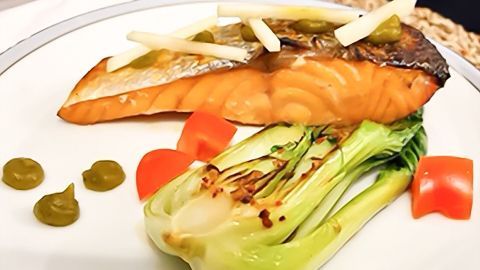 Saftiger Fischfilet liegt auf einem Teller, garniert mit Gemüse und Saucen, bereit zur schmackhaften Zubereitung.