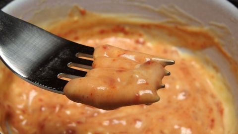 Eine Gabel mit Resten von Sauce Hollandaise, die in einer Schüssel gehalten wird, deutet auf kreative Weiterverwertung hin.