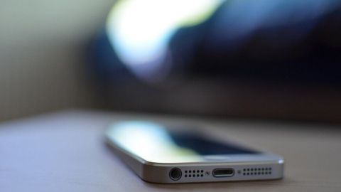 Ein Smartphone liegt auf einem Tisch, während es möglicherweise versucht, nach einem Wasserschaden wieder zu funktionieren.