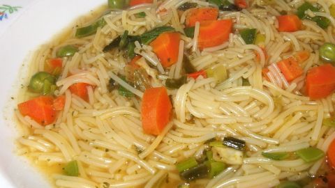 Ein Teller mit Nudeln, Gemüse und Brühe, der als Ersatz für Sherry beim Kochen dienen könnte, steht appetitlich bereit.