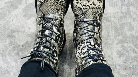 Schicke, schlangenlederartige Schuhe stehen auf einem hellen, eleganten Teppich, während sie den Raum der Umgebung erhellen.