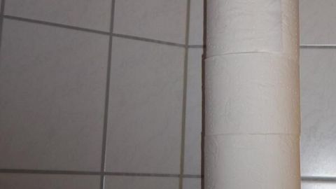 Hängende Toilettenpapierrollen sind an einer Kette befestigt, um im Badezimmer Platz zu sparen und zugänglich zu sein.