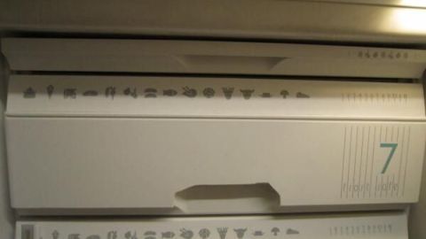 Ein Gefrierschrank zeigt verschiedene Fächer und Symbole. Er wird abgetaut, während Licht im Inneren scheint.