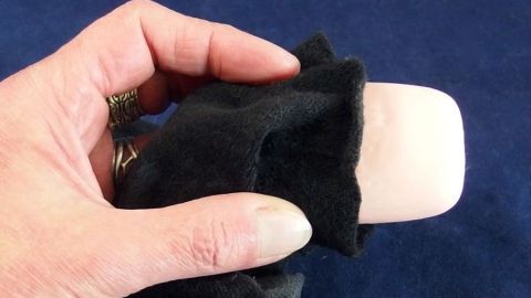 Eine Hand hält einen Kniestrumpf, der eine Seife verbirgt, ideal für Kinder zum Spielen und Lernen über Hygiene.