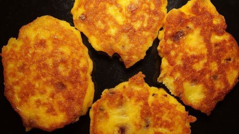 Kartoffelknödel liegen goldbraun in einer Pfanne, zeigen unregelmäßige Formen und sind lecker wie ein klassisches Gericht.