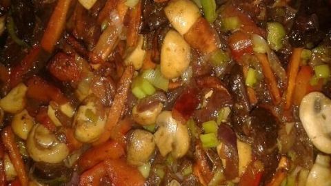 Gemüse brät in einer Pfanne; farbige Paprika, Pilze und Karotten sorgen für ein asiatisches Flair.