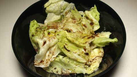 Ein Schüssel mit frischem Eisbergsalat wird appetitlich angerichtet, um mit verschiedenen Salatsoßen serviert zu werden.