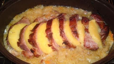 Zart geschnittener Kasslerbraten mit Ananas liegt in einer Brühe, umgeben von mildem, goldbraunem Gemüse.