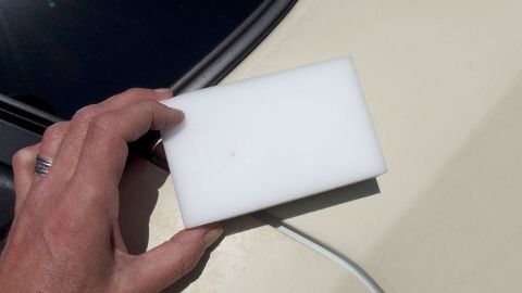 Das Entfernen von schwarzen Flecken an Autos gelingt sehr gut mithilfe eines Schmutzradiererers. Ein Schmutzradierer wird in der Hand gehalten, während damit schwarze Flecken von einer autolackierten Oberfläche entfernt werden.