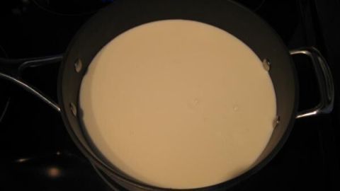 In einem großen Topf steht frische, cremige Masse, die darauf wartet, zu Quark aus Buttermilch verarbeitet zu werden.