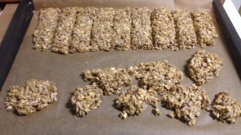 Kekse aus Sonnenblumenkernen sind auf einem Backblech angeordnet, bereit zum Backen in einer modernen Küche.
