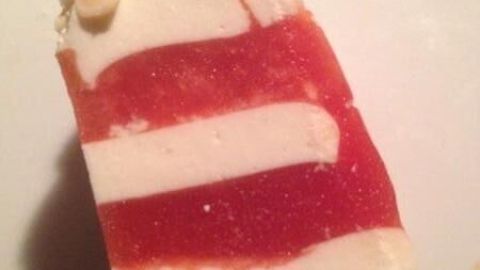 Eine schicke Terrine mit roten Schichten und Weißkäse, dekoriert mit Pinienkernen, auf einem Teller präsentiert.
