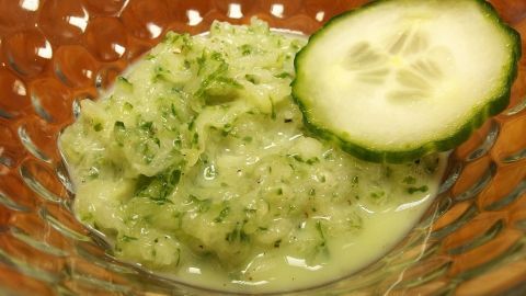 Ein Gurkensalat mit Milch in einer Schüssel, garniert mit einer Gurkenscheibe, erfrischend und grünlich-cremig.