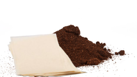 Kaffeepads liegen neben einem Haufen frisch gemahlenem Kaffee, bereit zur Zubereitung eines köstlichen Getränks.