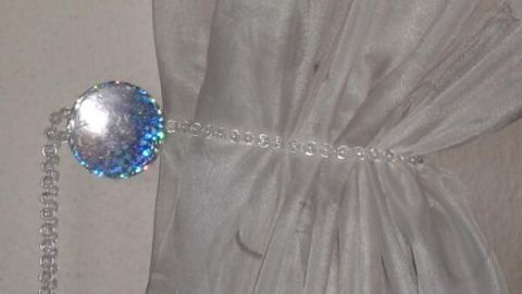 Ein eleganter Gardinen-Raffhalter hält einen transparenten Vorhang an einer Wand, ohne Bohren erforderlich zu sein.