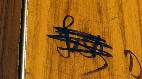 Ein schwarzer Filzstift hinterlässt ungewollte Spuren auf einer hellen Holzoberfläche, die gepflegt wirkt.