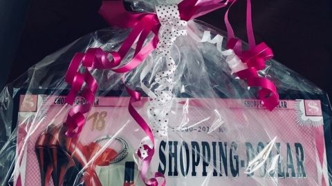 Ein hübsch verpacktes Geschenk für einen Teenager-Geburtstag liegt auf einem Tisch. Es enthält einen „Shopping-Dollar“.