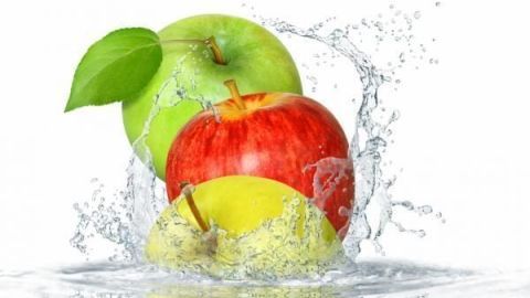 Äpfel spritzen im Wasser, symbolisierend das Waschen von Obst in einer klaren, erfrischenden Umgebung.
