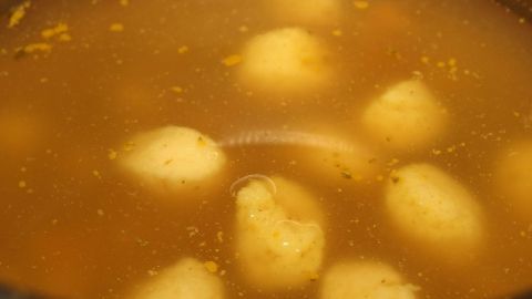 Suppen richtig würzen: Zu jeder Suppe gehören nicht nur Salz und Pfeffer, sondern auch ein Schuss Zitrone, und ein wenig Zucker. Eine klare Suppe mit Klößen schwimmt im Topf und wartet darauf, richtig gewürzt zu werden.
