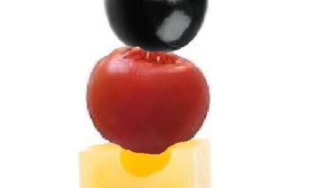 Ein Spieß mit Olive, Tomate und Käsewürfel steckt in einem Zahnstocher, vor weißem Hintergrund als Snack serviert.