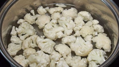 Blumenkohlstücke kochen in einem Topf mit Wasser, um Kohl ohne Gasentwicklung zuzubereiten.