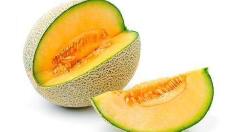 Zuckermelone, in zwei Teile geschnitten, auf weißem Hintergrund. Ein Stück liegt vor der halben Melone.