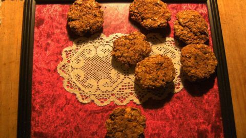Frikadellen liegen auf einem Tisch in einem schwarzen Rahmen, dekoriert mit rotem Stoff und weißen Spitzenuntersetzern.