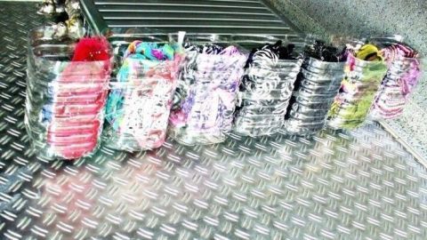 Bunte, pfandfreie Saftflaschen stehen ordentlich in einer Reihe auf einer glatten Metalloberfläche.