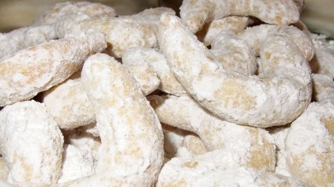 Leckere Vanillekipferl liegen in einer Schüssel, mit Puderzucker bestäubt, bereit zum Genießen.