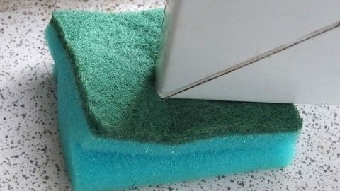 Ein Küchenschwamm fungiert als Türstopper, indem er den Raum zwischen der Tür und dem Boden blockiert.
