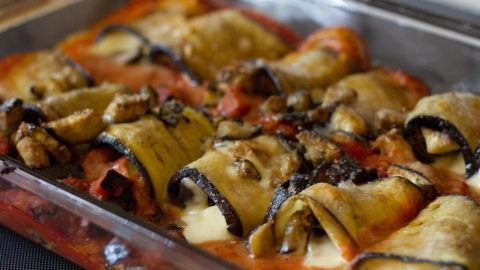 Auberginen-Cannelloni werden in einer Auflaufform mit Tomatensauce serviert, umgeben von einem köstlichen Käsebelag.