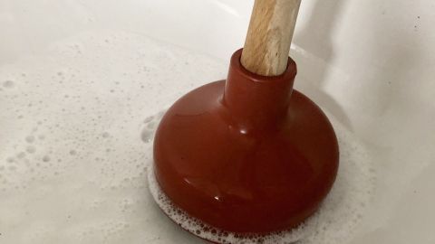 Einen verstopften Abfluss in der Dusche bekommt man mit einem Pümpel für die Toilette wieder frei.