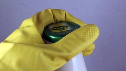 Eine Hand mit Gummihandschuh öffnet einen Flaschenverschluss, um Lebensmittel mit Konservengläsern leicht zugänglich zu machen.