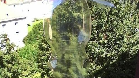 Eine PET-Flasche hängt an einem Fenster, gefüllt mit Vogelfutter, bereit, Vögel anzulocken, um sie zu füttern.