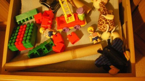 Ein bunter Kasten mit Spielzeug und Bauklötzen ist voller Möglichkeiten für kleine Kinder zum Spielen und Entdecken.