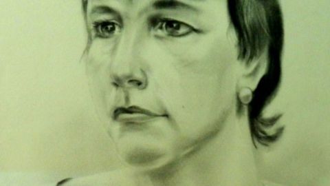 Ein Porträt einer Frau mit kurzen Haaren, die nachdenklich schaut, vor einem neutralen, unauffälligen Hintergrund.