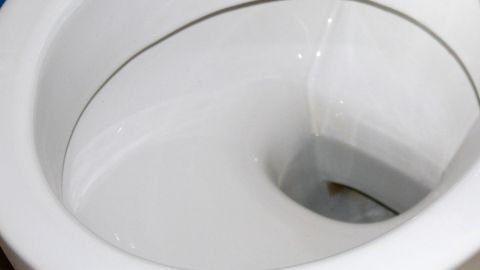 Funktioniert garantiert, belastet nicht die Umwelt und greift auch nicht die Glasur vom Toilettenbecken an. Eine Toilette zeigt Kalkablagerungen im inneren Bereich, die sich in einem sauberen Badezimmer befinden.