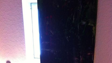 Ein dunkles Leinwandbild verdeckt ein Dachfenster, während sanftes Licht von der Seite strömt.