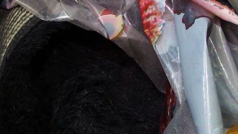 Langhaarige Badevorlagen liegen in einer abgedeckten Tasche, bereit für eine fusselfreie Wäsche in einem trockenen Raum.