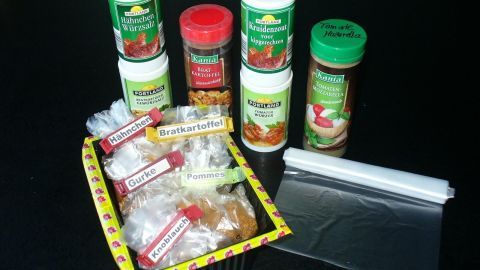 Eine Sammlung von Gewürzmischungen steht aufrecht in einer Anordnung, um sie praktisch aufzubewahren. Ein Behälter mit Etiketten ist daneben.