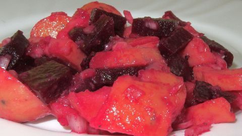 Warmer Rote-Bete-Kartoffelsalat präsentiert sich als bunter Salat aus gewürfelten Kartoffeln und Rote Bete, appetitlich angerichtet.