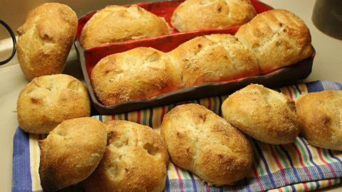 Frische Brötchen liegen auf einem Küchentuch, gebacken und goldbraun, bereit zum Servieren und Genießen.