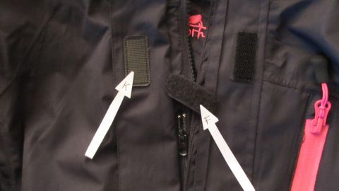 Schals sind an einem schwarzen Kleidungsstück sicher befestigt, ohne am Klettband zu verhaken, was die Nutzung erleichtert.