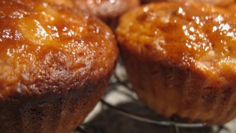 Glänzende Quitten-Muffins liegen auf einem Metallgitter, frisch gebacken und bereit zum Abkühlen.